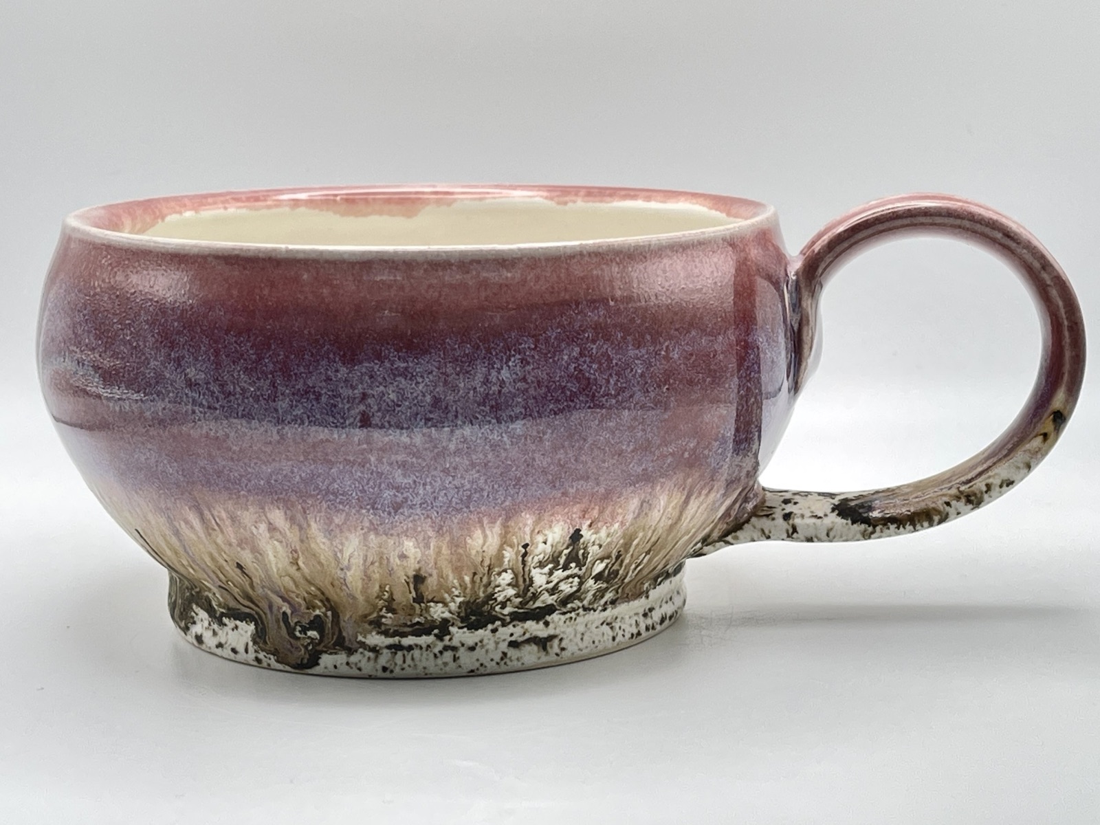 Purple wide bowl mug with speckled bottom and extruded handle